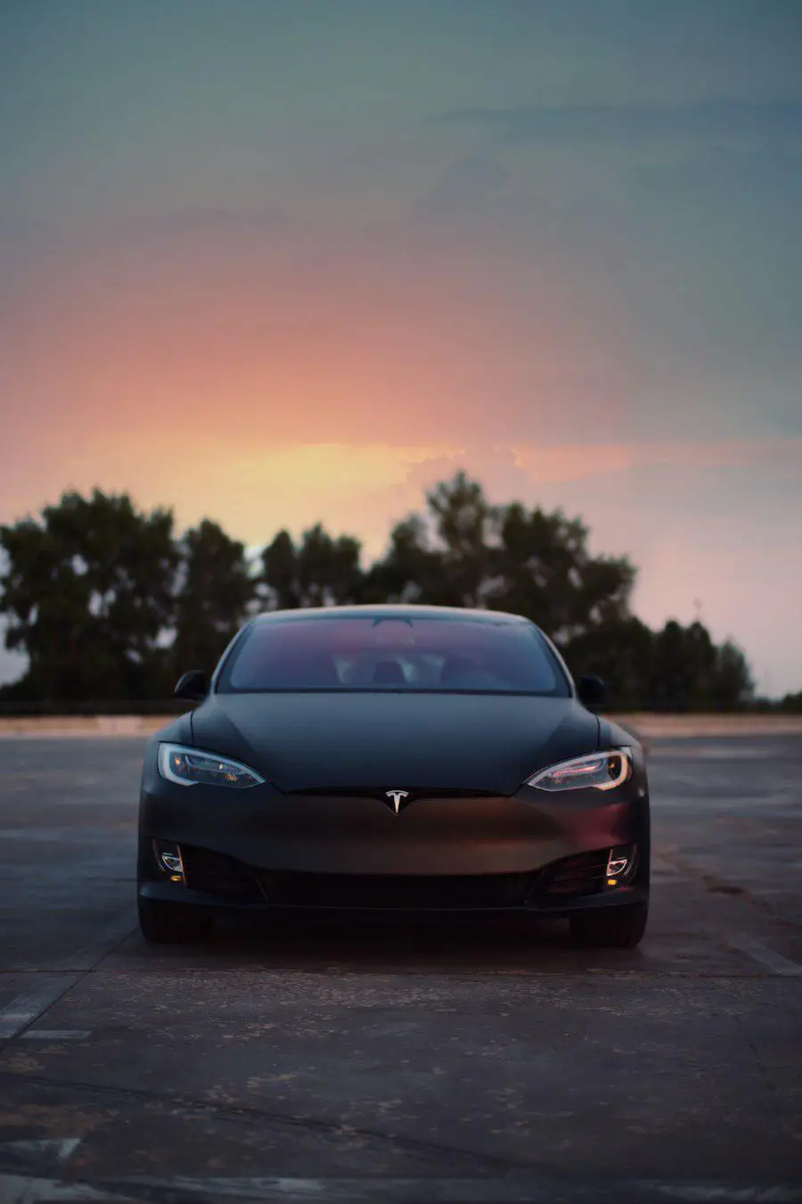 Electric car parked at dusk under an open sky